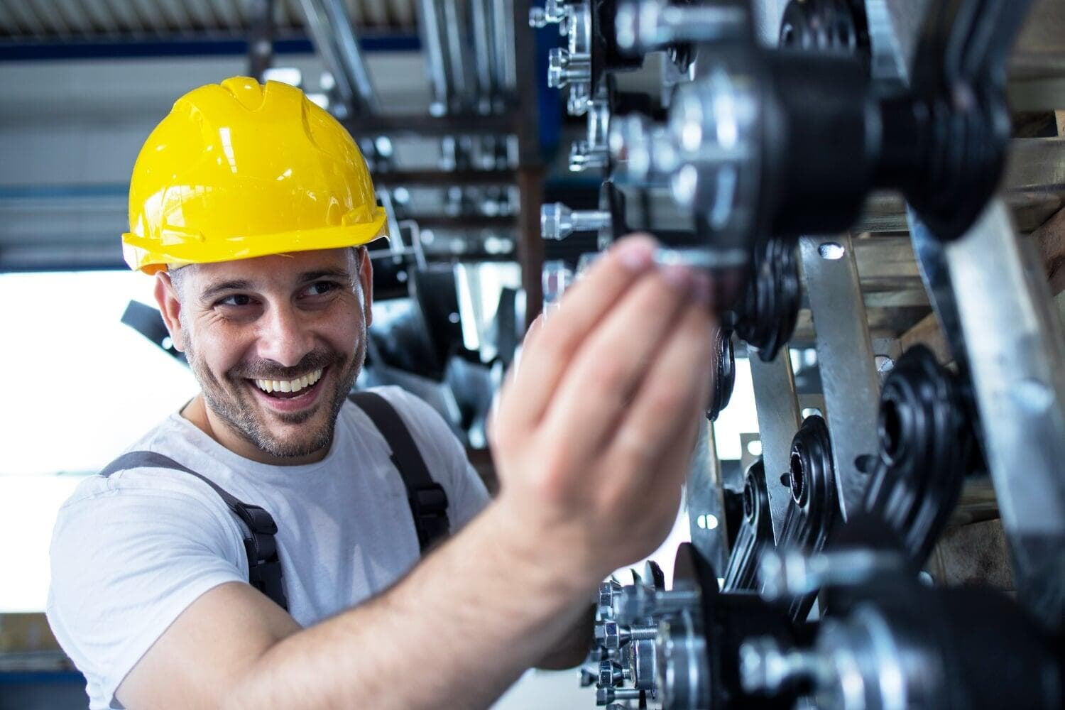 Smiling technician in a hard hat at a machine