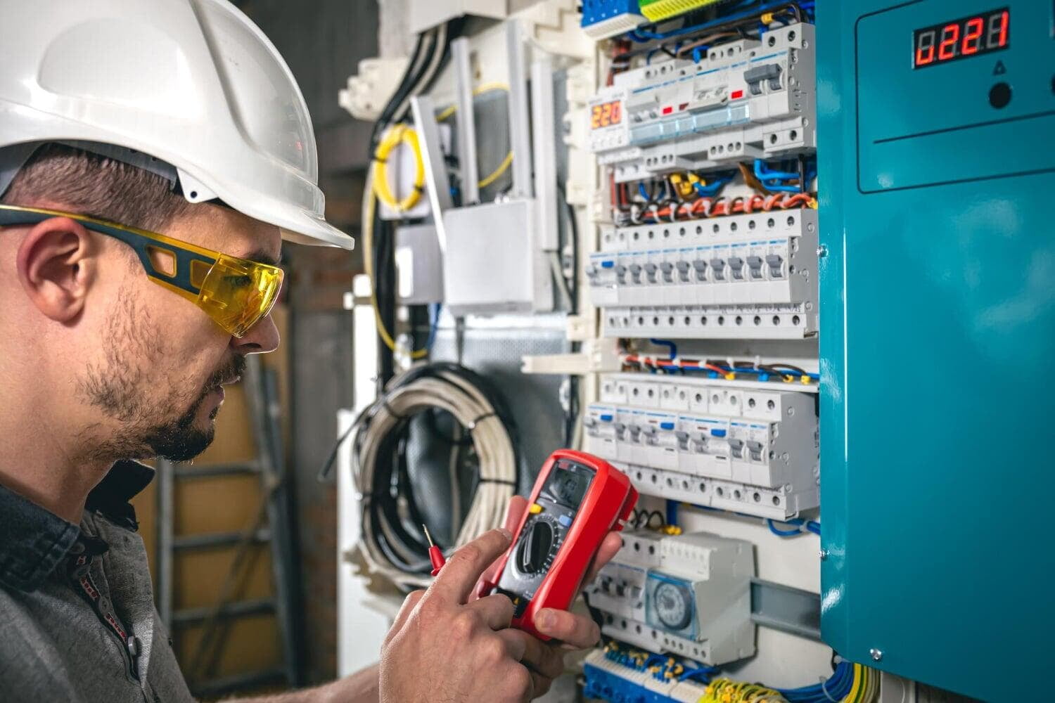 Elektriker prüft einen Schaltschrank mit Messgerät
